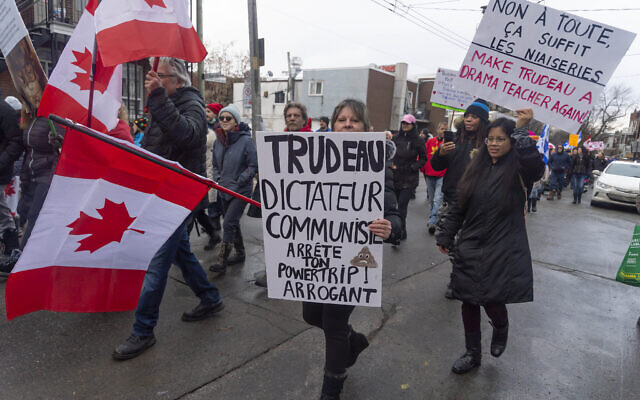 Protesters against COVID-19 restrictions march through the streets of Montreal, Feb. 12, 2022. (Peter McCabe /The Canadian Press via AP)