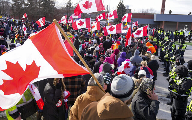 Police officers hold a line as protesters against COVID-19 restrictions march in Windsor, Ontario,  Feb. 12, 2022.  (Nathan Denette/The Canadian Press via AP)