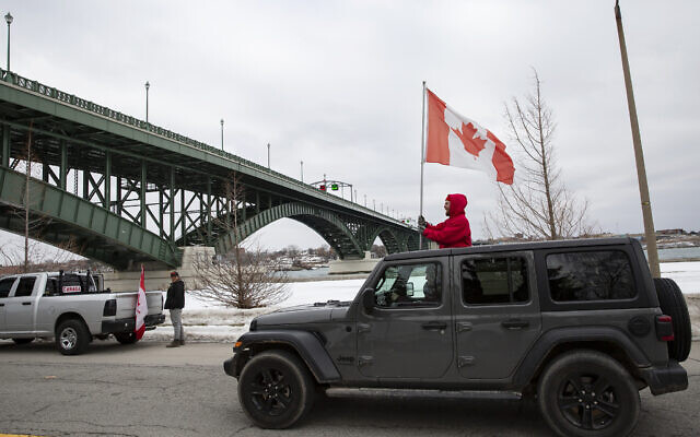 Demonstrators in opposition to COVID-19 mandates protest under the Peace Bridge in Fort Erie, Ontario, on Feb. 12, 2022. (Aaron Lynett/The Canadian Press via AP)