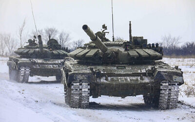 Russian tanks roll on the field during military drills in Leningrad region, Russia, February 14, 2022. (Russian Defense Ministry Press Service via AP)