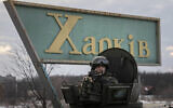 A Ukrainian National guard soldier guards the mobile checkpoint together with the Ukrainian Security Service agents and police officers during a joint operation in Kharkiv, Ukraine, February 17, 2022. (AP Photo/Evgeniy Maloletka)