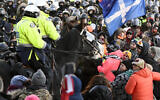 Protesters react as police mounted unit move in to disperse them as police take action to put an end to a protest, which started in opposition to mandatory COVID-19 vaccine mandates and grew into a broader anti-government demonstration and occupation, on February 18, 2022, in Ottawa. (Justin Tang/The Canadian Press via AP)