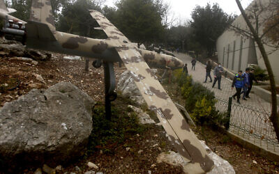 People walk by a replica drone in a war museum operated by Hezbollah in Mlita Village, southern Lebanon, February 19, 2022. (AP Photo/Mohammed Zaatari)