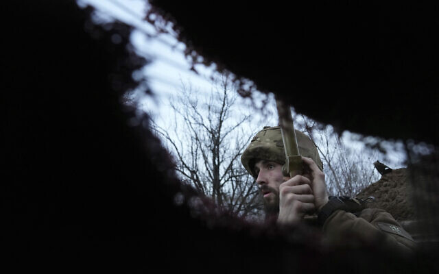 A Ukrainian service member listens to artillery shots standing in a trench on a position at the line of separation between Ukraine-held territory and rebel-held territory near Zolote, Ukraine, Feb. 19, 2022. (Evgeniy Maloletka/AP)