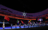 Flag bearers walk into the stadium for the closing ceremony of the 2022 Winter Olympics, Feb. 20, 2022, in Beijing. (AP Photo/Natacha Pisarenko)