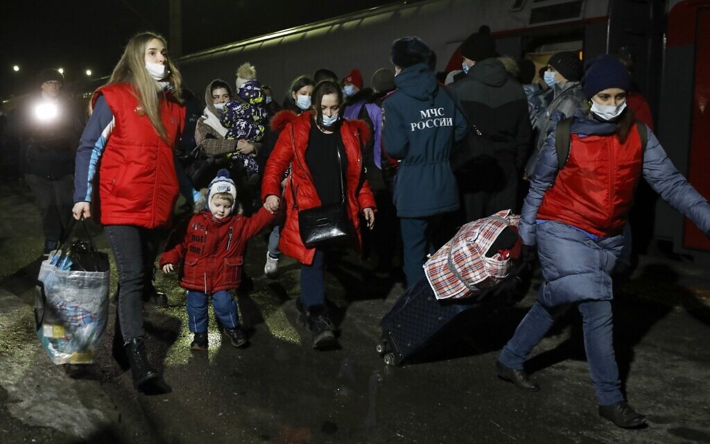 People from the Donetsk and Luhansk regions, the territory controlled by a pro-Russia separatist governments in eastern Ukraine, walk from a train to be taken to temporary residences in the Volgograd region, at the railway station in Volzhsky, Volgograd region, Russia, Feb. 20, 2022. (Alexandr Kulikov/AP)
