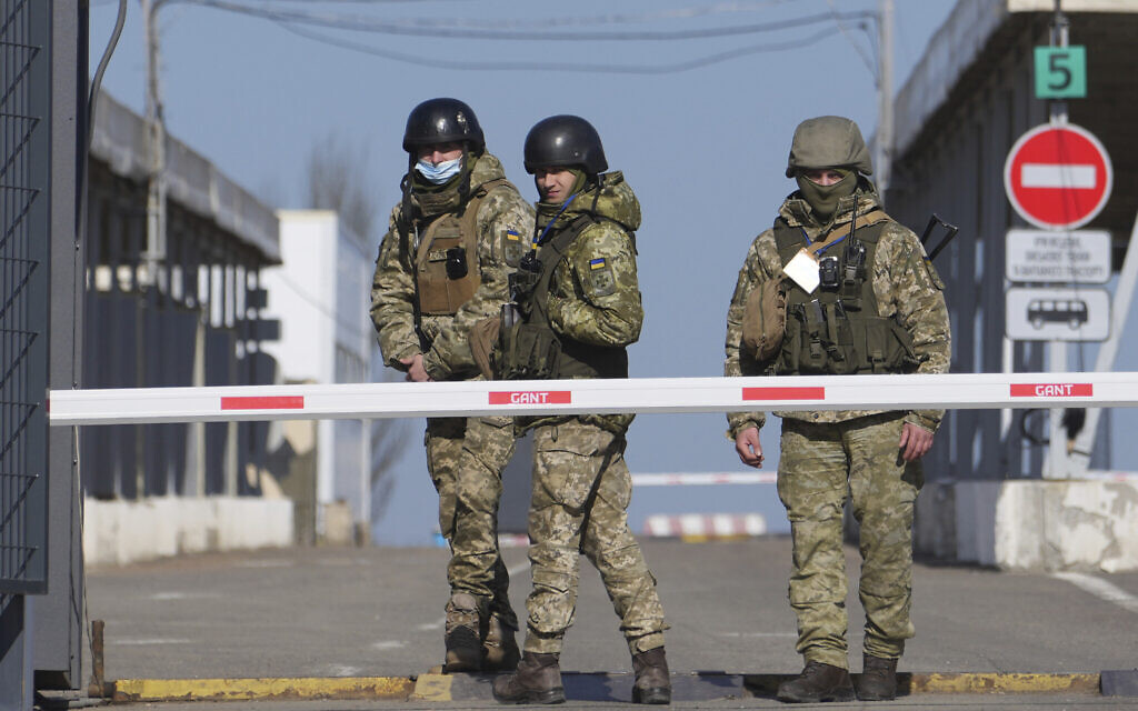 Ukrainian border guards stand at a checkpoint from territory controlled by Russia-backed separatists to the territory controlled by Ukrainian forces in Novotroitske, eastern Ukraine, Feb. 21, 2022. (Evgeniy Maloletka/AP)
