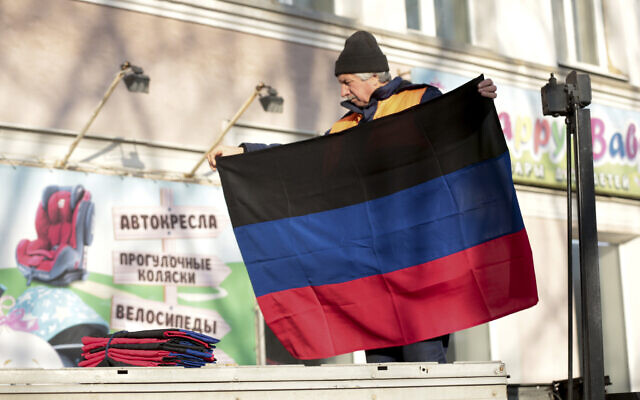 A municipal worker prepares to put up a Donetsk People Republic flag on a building in Donetsk, the territory controlled by pro-Russian militants, eastern Ukraine, Monday, Feb. 21, 2022. (AP/Alexei Alexandrov) A municipal worker prepares to put up a Donetsk People Republic flag on a building in Donetsk, the territory controlled by pro-Russian militants, eastern Ukraine, Monday, Feb. 21, 2022. (AP/Alexei Alexandrov)