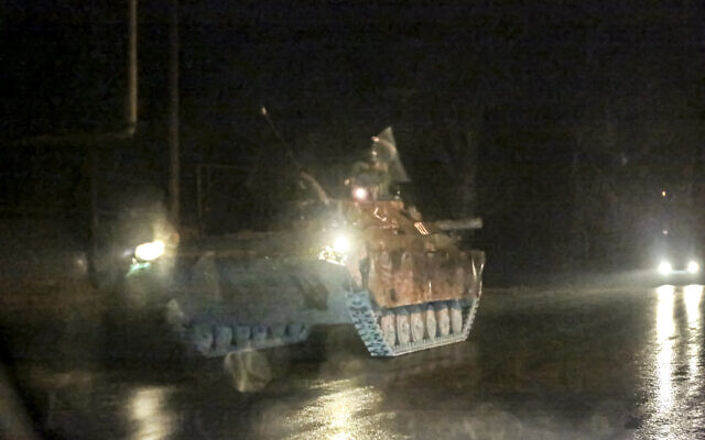 An armored vehicle rolls down a street outside Donetsk, the territory controlled by pro-Russian militants, eastern Ukraine, late Tuesday, February 22, 2022. (AP)
