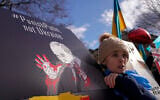 A demonstrator holds a placard as she attends a demonstration outside Downing Street, in London, February 24, 2022. (AP Photo/Alberto Pezzali)