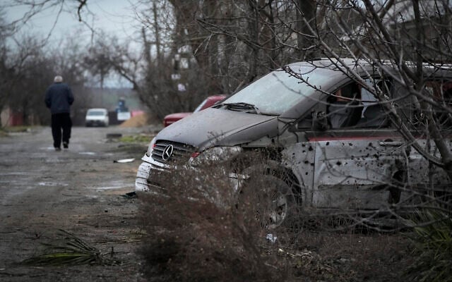 A man walks past a damaged vehicle and debris following Russian shelling in Mariupol, Ukraine, on Thursday, February 24, 2022. (AP Photo/Sergei Grits) A man walks past a damaged vehicle and debris following Russian shelling in Mariupol, Ukraine, on Thursday, February 24, 2022. (AP Photo/Sergei Grits)