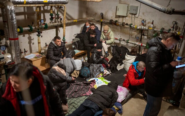 People take shelter at a building basement while the sirens sound announcing new attacks in the city of Kyiv, Ukraine, February 25, 2022. (AP/Emilio Morenatti)