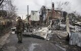 Ukrainian servicemen walk near fragments of a downed aircraft seen in in Kyiv, Ukraine, Friday, Feb. 25, 2022 (AP Photo/Oleksandr Ratushniak)
