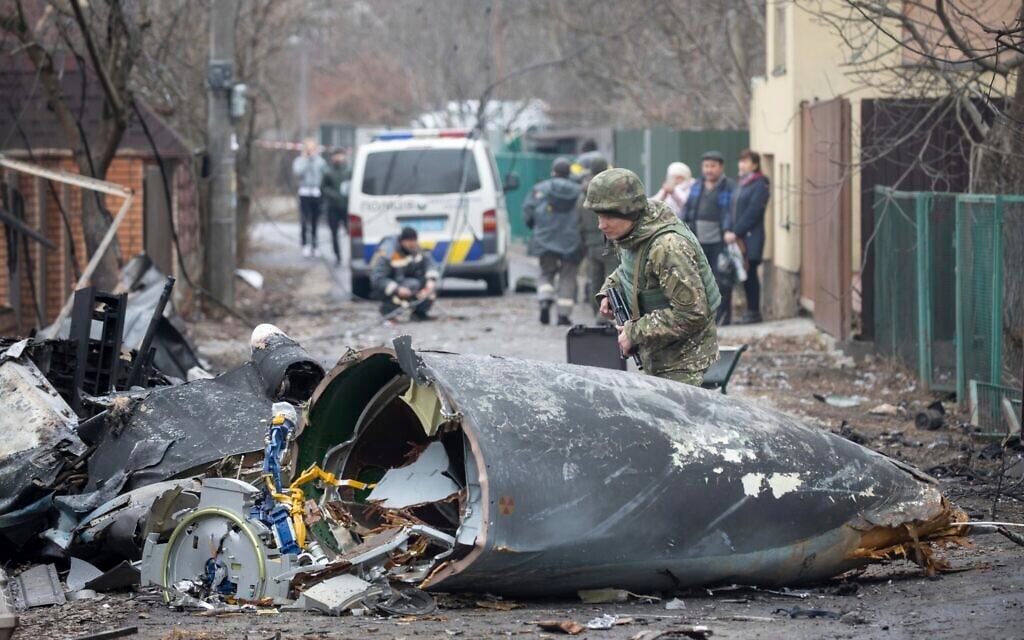 A Ukrainian Army soldier inspects fragments of a downed aircraft in Kyiv, Ukraine, February 25, 2022. (AP Photo/Vadim Zamirovsky)