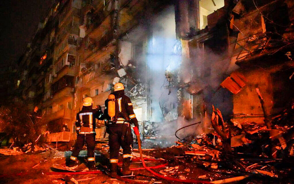 In this handout photo taken from video published by the Ukrainian Police Department Press Service on February 25, 2022, firefighters inspect the damage at a building following a rocket attack on the city of Kyiv, Ukraine (Ukrainian Police Department Press Service via AP)