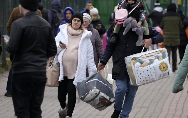 People fleeing the conflict from neighboring Ukraine arrive at the border crossing in Medyka, southeastern Poland, on Friday, February 25, 2022. (AP Photo/Czarek Sokolowski)