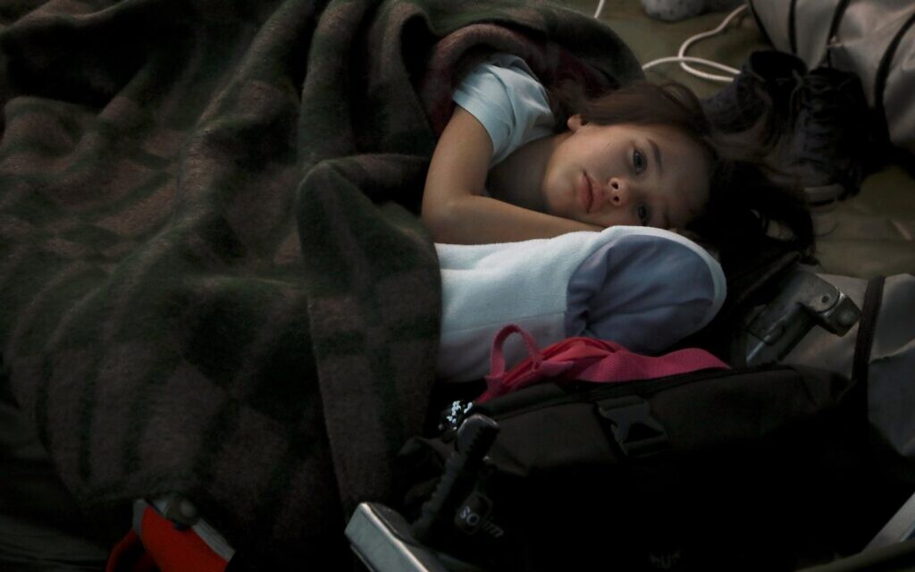 A child from Ukraine sleeps in a tent part of a humanitarian centre for refugees at the Moldovan-Ukrainian border, in Palalanca, Moldova, February 25, 2022 (AP Photo/Aurel Obreja)