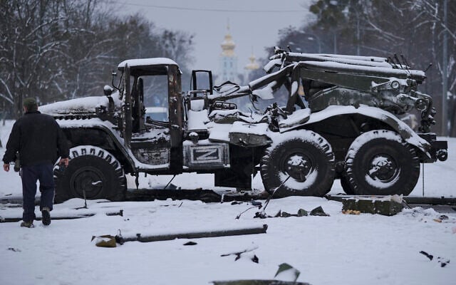 A man walks by a destroyed Russian military multiple rocket launcher vehicle on the outskirts of Kharkiv, Ukraine, Feb. 25, 2022. (Vadim Ghirda/AP)