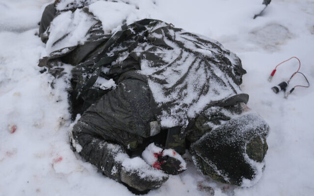 The body of a serviceman is coated in snow next to a destroyed Russian military multiple rocket launcher vehicle on the outskirts of Kharkiv, Ukraine, Friday, Feb. 25, 2022. (AP Photo/Vadim Ghirda) The body of a serviceman is coated in snow next to a destroyed Russian military multiple rocket launcher vehicle on the outskirts of Kharkiv, Ukraine, Friday, Feb. 25, 2022. (AP Photo/Vadim Ghirda)