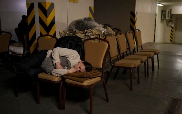 A woman sleeps on chairs in the underground parking lot of a hotel that has been turned into a bomb shelter during an air raid alert in Kyiv, Ukraine, Feb. 27, 2022. (Vadim Ghirda/AP) A woman sleeps on chairs in the underground parking lot of a hotel that has been turned into a bomb shelter during an air raid alert in Kyiv, Ukraine, Feb. 27, 2022. (Vadim Ghirda/AP)