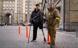 Armed civil defense men pose for a photo while patrolling an empty street due to curfew in Kyiv, Ukraine, Feb. 27, 2022 (AP Photo/Efrem Lukatsky)