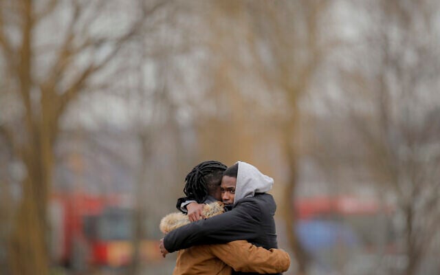 People who fled the conflict from neighboring Ukraine embrace after crossing the Romanian-Ukrainian border, in Siret, Romania, February 27, 2022. (AP Photo/Andreea Alexandru)