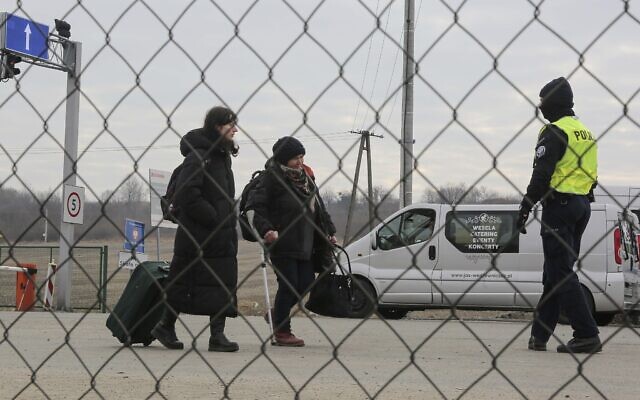 Police officers directs refugees fleeing conflict in Ukraine as they arrive, at the Medyka border crossing, in Poland, Sunday, Feb. 27, 2022. (AP Photo/Visar Kryeziu) Police officers directs refugees fleeing conflict in Ukraine as they arrive, at the Medyka border crossing, in Poland, Sunday, Feb. 27, 2022. (AP Photo/Visar Kryeziu)