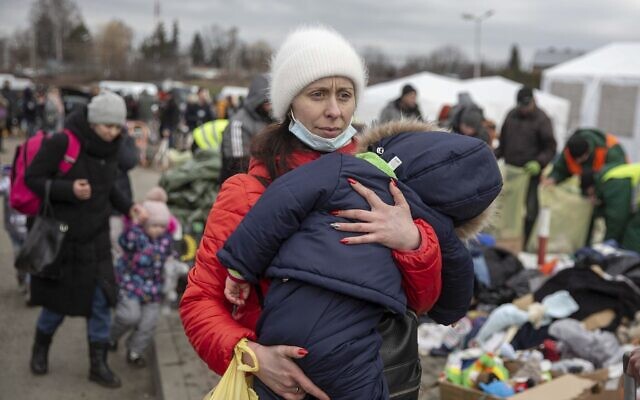 A woman carries her child as she arrives at the Medyka border crossing after fleeing from Ukraine, in Poland, February 28, 2022. (AP Photo/Visar Kryeziu) A woman carries her child as she arrives at the Medyka border crossing after fleeing from Ukraine, in Poland, February 28, 2022. (AP Photo/Visar Kryeziu)