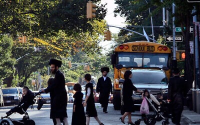 In this September 20, 2013 file photo, children and adults cross a street in front of a school bus in Borough Park, a neighborhood in the Brooklyn borough of New York that is home to many ultra-Orthodox Jewish families. (AP Photo/Bebeto Matthews, File) In this September 20, 2013 file photo, children and adults cross a street in front of a school bus in Borough Park, a neighborhood in the Brooklyn borough of New York that is home to many ultra-Orthodox Jewish families. (AP Photo/Bebeto Matthews, File)