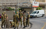 Illustrative: Israeli soldiers wearing face masks are seen at the entrance of Jish, in Northern Israel, July 27, 2020. (Flash90)