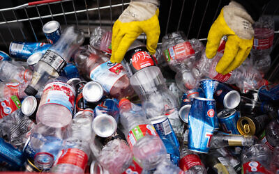 A man sorting bottles for recycling in Jerusalem, February 1, 2022. (Nati Shohat/Flash90)