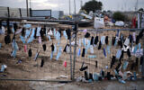 Face masks hang on a fence in Glilot, February 14, 2022. (Tomer Neuberg/ Flash90)
