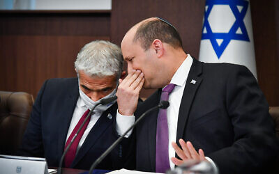Prime Minister Naftali Bennett speaks with Foreign Minister Yair Lapid during a cabinet meeting at the Prime Minister's Office in Jerusalem, on February 27, 2022. (Yoav Ari Dudkevitch/Pool)