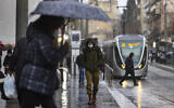 People wearing face masks walk in Jerusalem, on February 10, 2022. (Olivier Fitoussi/Flash90)