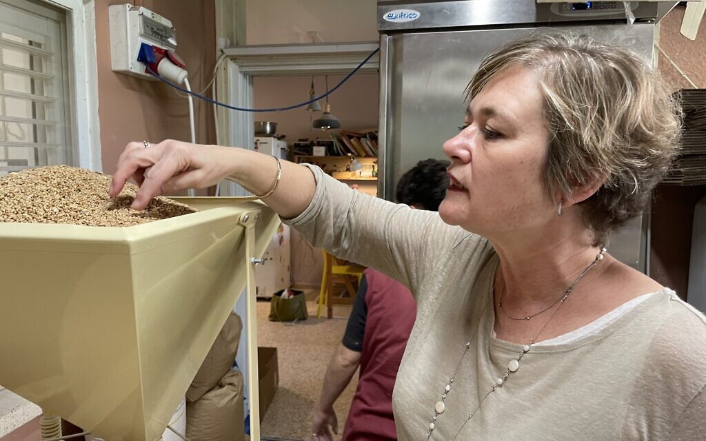 Cookbook author Ruth Nieman looking at grains being milled in Hagay and The Bread, the Kibbutz Einat bakery of Hagay Ben Yehuda on February 23, 2022 (Jessica Steinberg/Times of Israel) Cookbook author Ruth Nieman looking at grains being milled in Hagay and The Bread, the Kibbutz Einat bakery of Hagay Ben Yehuda on February 23, 2022 (Jessica Steinberg/Times of Israel)
