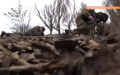 Ukraine's interior minister and soldiers duck for cover outside Novoluganske, in the Donetsk region of eastern Ukraine, on February 19, 2022. (Screenshot/Twitter)