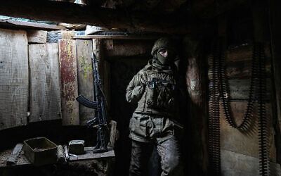 A Ukrainian serviceman stands in a shelter on a position at the line of separation between Ukraine-held territory and rebel-held territory near Zolote, Ukraine, on February 19, 2022. (AP/Evgeniy Maloletka)