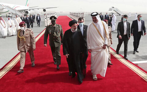 In this photo released by the official website of the office of the Iranian Presidency, President Ebrahim Raisi, center, is welcomed by Qatari Emir Tamim bin Hamad Al Thani, center right, as he arrives in Doha, Qatar, Feb. 21, 2022. (Iranian Presidency Office via AP)