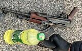 An AK-type assault rifle and a bottle of flammable liquid is seized by officers in northern Israel, on February 19, 2022. (Israel Police)