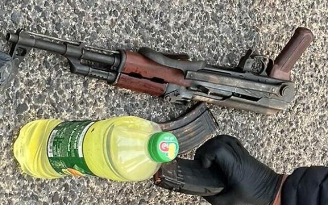 An AK-type assault rifle and a bottle of flammable liquid is seized by officers in northern Israel, on February 19, 2022. (Israel Police) An AK-type assault rifle and a bottle of flammable liquid is seized by officers in northern Israel, on February 19, 2022. (Israel Police)