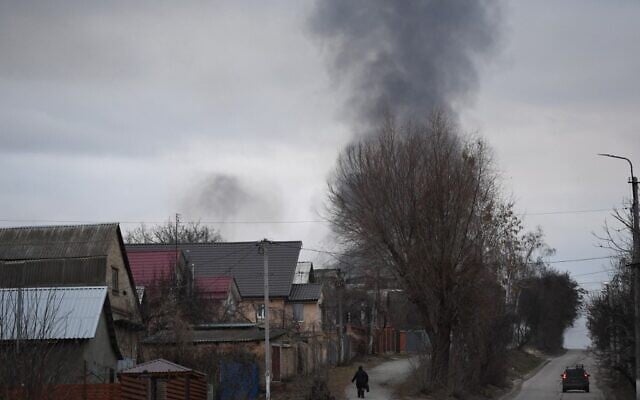 Illustrative -- A local resident walks in a street as smoke rises near the town of Hostomel and the Antonov Airport, in northwest Kyiv on February 24, 2022 (Daniel LEAL / AFP) Illustrative -- A local resident walks in a street as smoke rises near the town of Hostomel and the Antonov Airport, in northwest Kyiv on February 24, 2022 (Daniel LEAL / AFP)