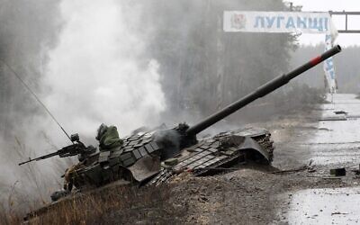 Smoke rises from a Russian tank destroyed by the Ukrainian forces on the side of a road in Lugansk region, on February 26, 2022. (Anatolii Stepanov/AFP)