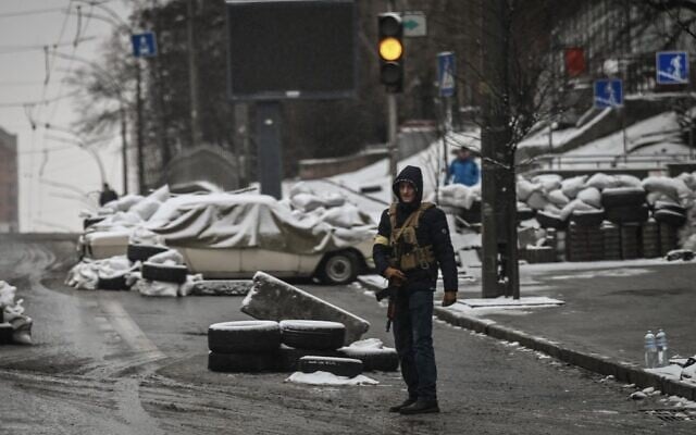 An armed man stands at a road block in downtown Kyiv on March 1, 2022. (Aris Messinis/AFP)