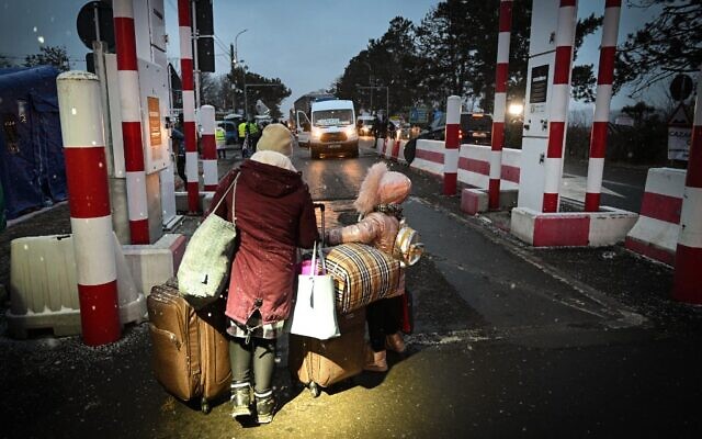 A Ukrainian mother and her child walk at the Siret border point with Ukraine in Siret city March 1, 2022. (Daniel MIHAILESCU / AFP) A Ukrainian mother and her child walk at the Siret border point with Ukraine in Siret city March 1, 2022. (Daniel MIHAILESCU / AFP)