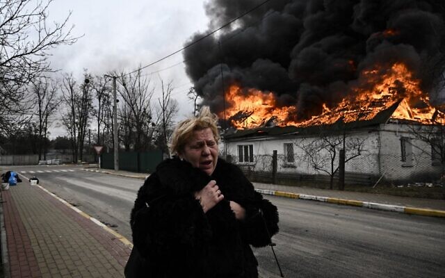 A woman reacts as she stands in front of a house burning after being shelled in the city of Irpin, outside Kyiv, on March 4, 2022. (Aris Messinis/AFP) A woman reacts as she stands in front of a house burning after being shelled in the city of Irpin, outside Kyiv, on March 4, 2022. (Aris Messinis/AFP)