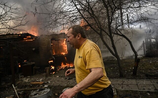 Yevghen Zbormyrsky, 49, runs in front of his burning house after being shelled in the city of Irpin, outside Kyiv, on March 4, 2022 (Aris Messinis / AFP) Yevghen Zbormyrsky, 49, runs in front of his burning house after being shelled in the city of Irpin, outside Kyiv, on March 4, 2022 (Aris Messinis / AFP)