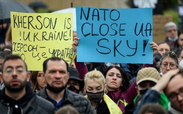 Protestors hold signs reading "Kherson is Ukraine!" and "NATO, close Ukraine's sky" during a demonstration in support of Ukraine and to protest against Russia's invasion of the country, on the Plaza Catalunya square in Barcelona, on March 6, 2022. (Photo by LLUIS GENE / AFP)