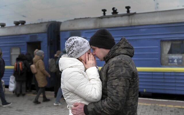 A couple embrace as they stand in front of an evacuation train at the central train station in Odesa on March 6, 2022. (BULENT KILIC / AFP) A couple embrace as they stand in front of an evacuation train at the central train station in Odesa on March 6, 2022. (BULENT KILIC / AFP)