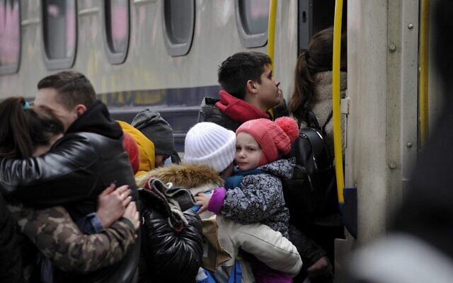 A woman holds a toddler before stepping up in an evacuation train at the central train station in Kyiv on March 6, 2022. (SERGEI CHUZAVKOV / AFP) A woman holds a toddler before stepping up in an evacuation train at the central train station in Kyiv on March 6, 2022. (SERGEI CHUZAVKOV / AFP)