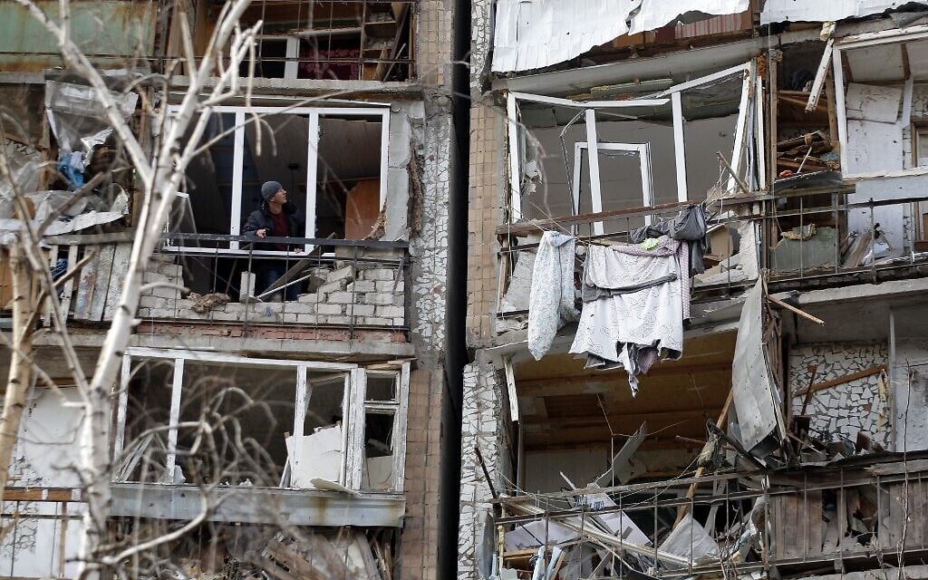 A resident looks out of the destroyed front of a room in a multi-story building that was badly damaged as a result of Russian missile explosion after it was shot down over the city by Ukrainian air defense on March 6, in Kramatorsk on March 7, 2022. (Anatolii Stepanov / AFP)